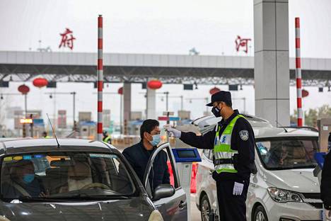Poliisi mittaa lämpöä mieheltä Wuhanissa.