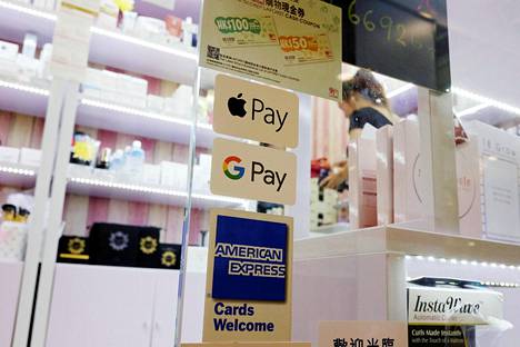 Apple Payn ja Google Payn mobiilimaksusovellusten symbolit kaupan ikkunassa ostoskeskuksessa Hongkongissa heinäkuussa.