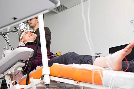 Kun liikeaivokuori sai magneettipulssin, jalkaterä liikahti. Lääketieteen opiskelija Roope Havu kokeilee aivojen ja lihasten stimulaatiota terveellä koehenkilöllä Paula Havulla Biomag-laboratoriossa Helsingin Meilahdessa.
