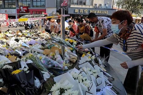 Ihmiset jättivät kukkia puukotuksen tapahtumapaikalle sunnuntaina Kiinan Anqingissa.