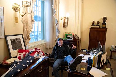 Capitolin valtaajiin kuulunut Richard Barnett nosti jalan Yhdysvaltain edustajainhuoneen puhemiehen Nancy Pelosin työpöydälle 6. tammikuuta 2021.