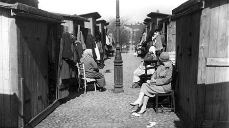 Vaatetavaraa ripustettuna näytteille juutalaisten torilla eli Narinkassa. Kuva on vuodelta 1929, jolloin Simonkadun varressa ollut myyntipaikka lakkautettiin.