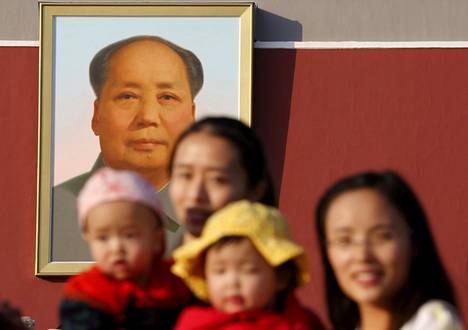 Kaksi kiinalaisnaista vauvoineen kuvattiin Kiinan entisen johtajan Mao Zedongin valokuvan edessä. 