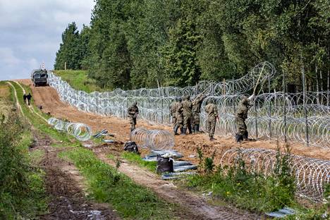 Puolalaissotilaat virittivät piikkilanka-aitaa Valko-Venäjän rajalle Minkowcen kylän lähistöllä syyskuun alussa.