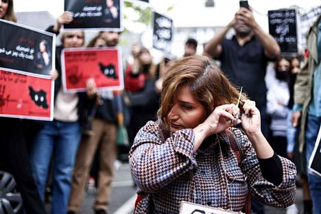 Nainen leikkasi hiuksensa protestoidakseen Mahsa Aminin väkivaltaista kuolemaa vastaan Iranin suurlähetystön edustalla Brysselissä perjantaina. 