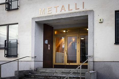 Sisäänkäynnin yläpuolella taloon astuvaa tervehtii taloyhtiön nimi, joka on Metalli. Koko nimi on Lauttasaaren Metalli.