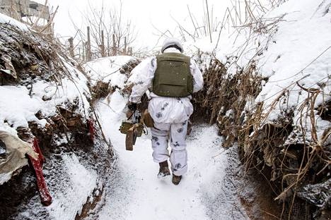 Ukrainalaissotilas käveli tuoreen lumen peittämässä taisteluhaudassa tammikuussa 2022. Ukrainan asevoimien 25. maahanlaskuprikaatin laskuvarjojääkärit olivat asemissa sodan tuhoaman teollisuusalueen raunioissa Avdiivkassa noin 12 kilometrin päässä Donetskin keskustasta pohjoiseen.