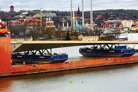 Slussenin uusi silta saapui Tukholmaan rahtilaivan kyydissä, ponttonien päälle laskettuna. Sen odotetaan kestävän ainakin 120 vuotta.
