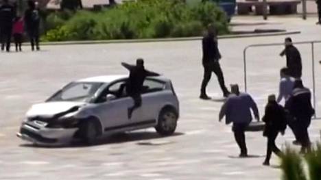 Albania | Video näyttää, kuinka mies hyppäsi jalat edellä auton ikkunasta sisään pysäyttääkseen Albanian pääkaupungin aukiolla valtoimenaan pyörineen auton