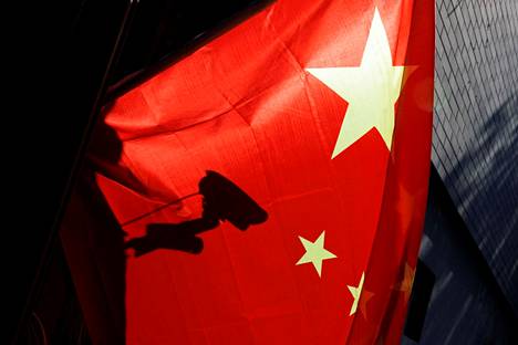 Valvontakamera näkyi siluettina Kiinan lipun lävitse Pekingissä 3. marraskuuta otetussa valokuvassa.
