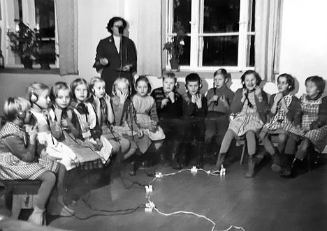 Teaching speaking at the Oulu School for the Deaf in the 1960s.  Students try to listen to the words spoken by the teacher through the headphones.  “If you heard something, you had to raise your hand,” says Anna-Leena Lahdenperä (pictured Fifth from left).