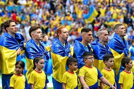 Ukraine's players wrapped themselves in the country's flags before the opening of the European Championship.  In the match, Ukraine suffered a 0–3 loss to Romania.