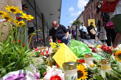 Ihmiset toivat kukkia ja kynttilöitä onnettomuuspaikalle Etelä-Saksan Würzburgissa lauantaina.