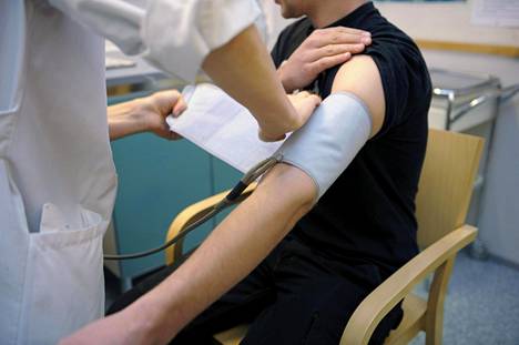 Lääkäri mittaa potilaan verenpainetta terveysasemalla.
