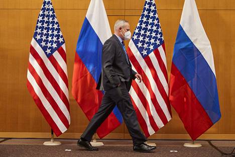 Neuvotteludelegaation jäsen kuvattiin ohittamassa Yhdysvaltain ja Venäjän lippuja Geneven kokouspaikalla maanantaina.