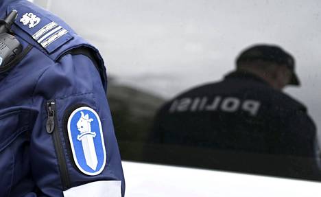 Helsingin poliisi poliisiauton edessä.