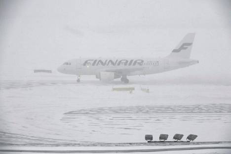 Finnairin lentokone Helsinki-Vantaan lentokentällä sankassa lumisateessa keskiviikkona 24. tammikuuta 2018. Finnair on perunut useita lentoja Helsinki-Vantaan lentoasemalta lumentulon vuoksi. Puoli yhden aikaan päivällä peruutettuja lentoja oli jo kymmenen.