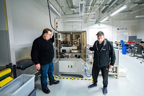 Salofan tehtaanjohtaja Jarmo Nykänen (vas.) ja hallituksen puheenjohtaja Thommy Hellberg esittelevät koronapikatestejä tekevää robottia.