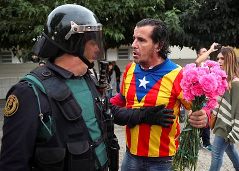 Katalonian separatistilippuun pukeutunut mies ja Espanjan keskushallinnon Kataloniaan määräämä santarmi vastakkain Sant Juliá de Ramisissa sunnuntaina.