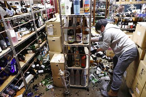 Alkoholiliikkeen myyjä siivosi maanjäristyksen tuhoja Fukushimassa lauantaina.