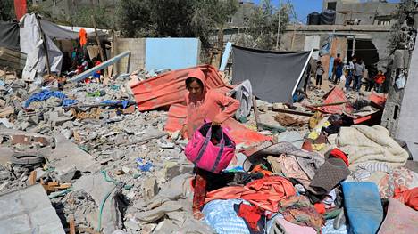 Nuori nainen keräsi tavaroita raunioiden keskeltä Rafahissa tiistaina. 