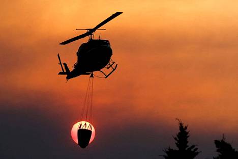 Helikopteri kuljetti sammutusvettä maastopalojen vaivaamassa Alhaurin el grandessa perjantaina.