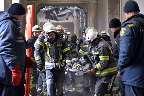 Pelastustyöntekijät kantoivat ruumista iskun kohteeksi joutuneesta hallintorakennuksesta Harkovassa tiistaina.
