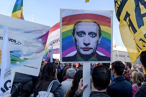 Mielenosoittaja pitää kädessään Venäjän presidentti Vladimir Putinia esittävää julistetta LGBT-järjestöjen mielenosoituksen aikana Venäjän suurlähetystön edessä Roomassa 22. huhtikuuta 2017.