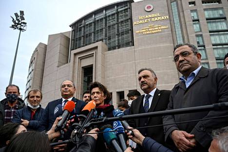 Vangitun liikemiehen Osman Kavalan vaimo Ayşe Buğra (keskellä) puhui medialle Kavalan vankeuden jatkamisesta päättäneen tuomioistuimen edessä Istanbulissa perjantaina.