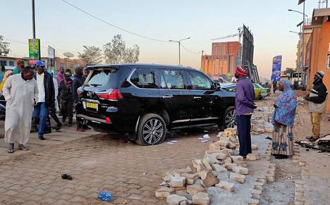 Ihmiset katsoivat Burkina Fason pääkaupungissa Ouagadougoussa maanantaina presidentinhallinnolle kuuluvaa autoa, jota oli ammuttu.