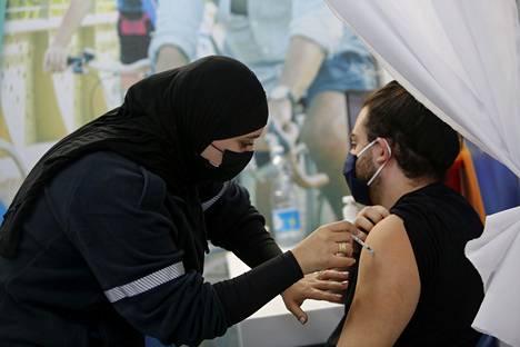 Israelilainen mies sai koronavirusrokotteen maanantaina Tel Avivissa.