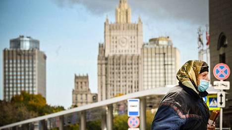 Maskiin pukeutunut nainen kantoi kädessään tuohuksia eli kirkkokynttilöitä Moskovan keskustassa tiistaina.