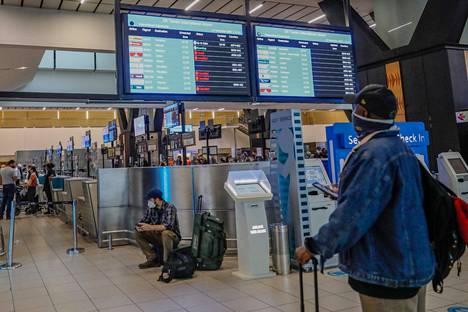 Matkustaja tarkasteli peruttujen lentojen listaa Tambon kansainvälisellä lentokentällä Johannesburgissa 27. marraskuuta.