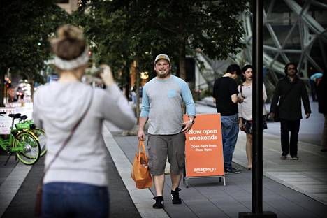 Minnesotalaiset turistit Rory McLafferty ja Karen Johnson tahtoivat ikuistaa itsensä ensimmäisen Amazon Go -kaupan edustalla Seattlessa. Kassattomasta kaupasta on tullut nähtävyys.