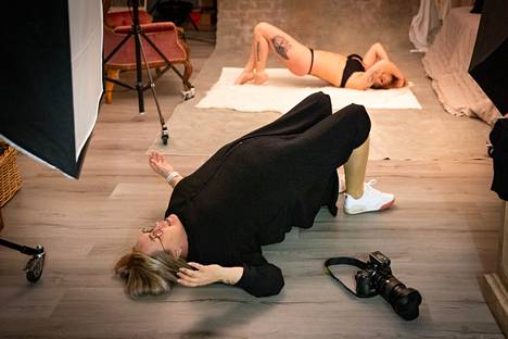 Inga Moisio heittäytyy itse lattialle ja näyttää harjoitusmallilleen Sini Moisiolle, miten napa tulee nostaa kohti kattoa kuvanottohetkellä.