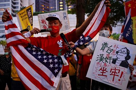 Mielenosoittaja repi Yhdysvaltojen lipun kahtia Nancy Pelosin vierailua vastustavassa mielenosoituksessa Taipeissa 2. elokuuta. Kyltissä Pelosia luonnehdittiin ”petturiksi” ja ”rikolliseksi”.