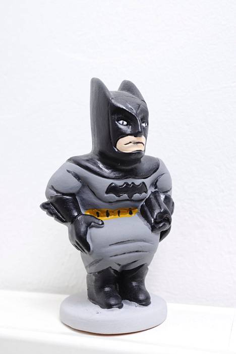 The crouching and pooping Batman statue is delicately depicted from the front.