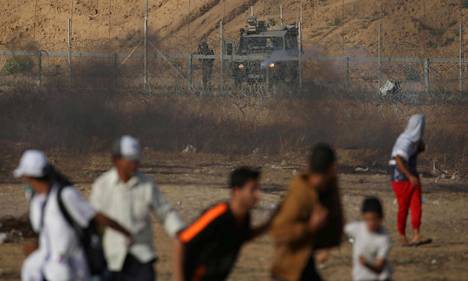 Israelilaissotilas tähtäsi aseellaan palestiinalaismielenosoittajia kohti Gazan ja Israelin rajalla perjantaina.