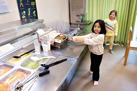 Athena Atayi, 4, ja Venla Kurasto, 5, esittelevät päiväkodin ruokalan. Esikoululaiset ottavat ruokaa itse ja pienemmille annostellaan.