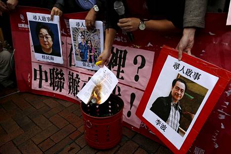 Hongkongilainen mielenosoittaja poltti kirjeen Gui Minhain ja muiden kadonneiden kirja-alan ihmisten kuvien edessä tammikuussa 2016. Gui Minhain kuva on äärimmäisenä vasemmalle.