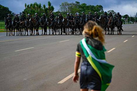 Jair Bolsonaron kannattaja kohtasi leiriä purkamaan tulleet ratsupoliisit asevoimien päämajan edustalla Brasíliassa maanantaina.