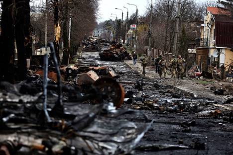 Ukrainian soldiers walked past the destroyed Russian military in Butcha on Saturday.