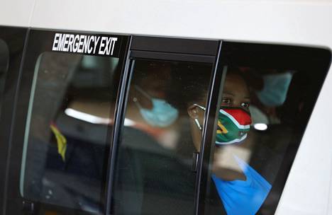 Taksimatkustaja pitää kasvoillaan Etelä-Afrikan lipun väreihin verhottua kangasmaskia perjantaina Sowetossa Etelä-Afrikassa.