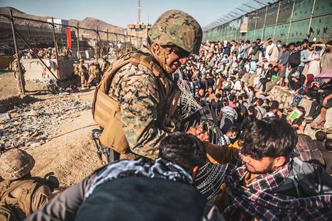 Yhdysvaltain merijalkaväen sotilas avusti ihmisiä evakuointien aikana Afganistanin pääkaupungin Kabulin lentokentällä elokuun 26. päivä 2021.