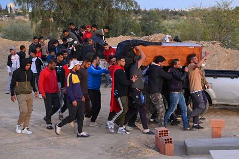 Miehet kantoivat ammattijalkapalloilija Nizar Issaouin arkkua Haffouzin kylässä Tunisian keskiosiin huhtikuun 14. päivänä. Issaouin veljen mukaan Nizar Issaoui sytytti itsensä tuleen vastalauseeksi poliisivaltioksi muuttuneelle Tunisialle.