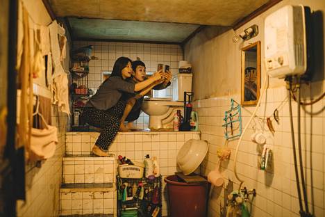 Kimin perheen ahtaan kodin vessanpytylläkin on tärkeä symbolimerkitys Parasite-elokuvassa. Kuvassa lapset (Park So Dam ja Choi Woo Sik) etsivät ilmaista wifiä.