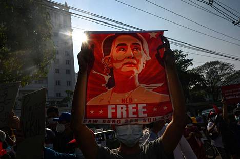 Mielenosoittaja kantoi Aung San Suu Kyin kuvaa Myanmarin keskuspankin edustalla helmikuussa 2021.