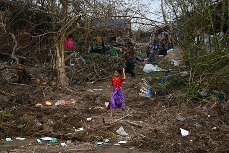Pieni lapsi käveli tuhoutuneiden asumusten ja puiden keskellä rohigya-pakolaisleirissä maanantaina Sittwessa Rakhinen alueella Myanmarissa.