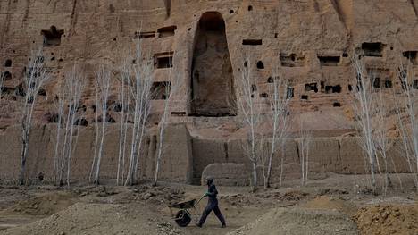 Afganistanilaismies 1 500 vuotta vanhan Buddha-patsaan edessä Bamiyanissa vuonna 2023 otetussa kuvassa.