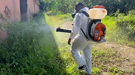 Työntekijä savusti hyttysiä talon läheisyydestä Puerto Ricossa. 